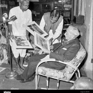 old-vintage-black-and-white-1900s-picture-of-indian-photographer-buyer-mounted-prints-india-1950s-2RF2P93